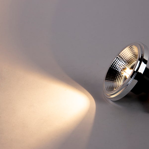 LED-Reflektorlampe mit warmweißem Lichtstrahl auf einer Oberfläche.