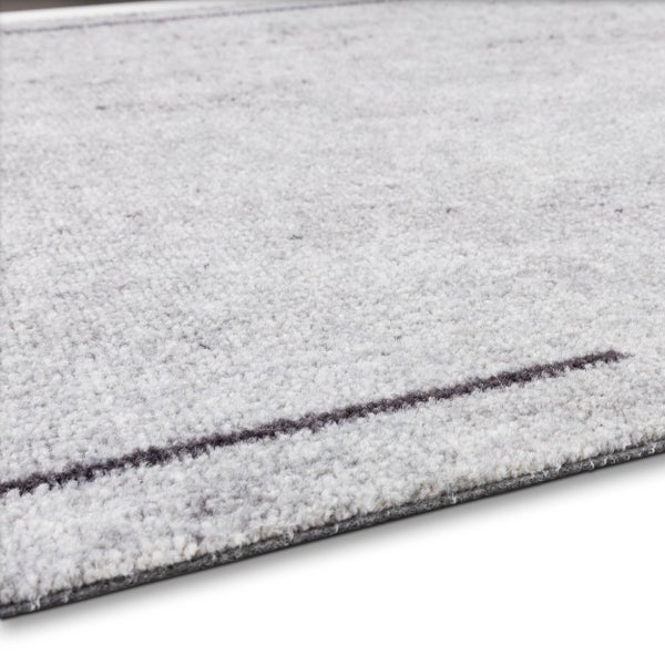 Grauer Teppich mit weicher Textur und einer dunklen horizontalen Linie.