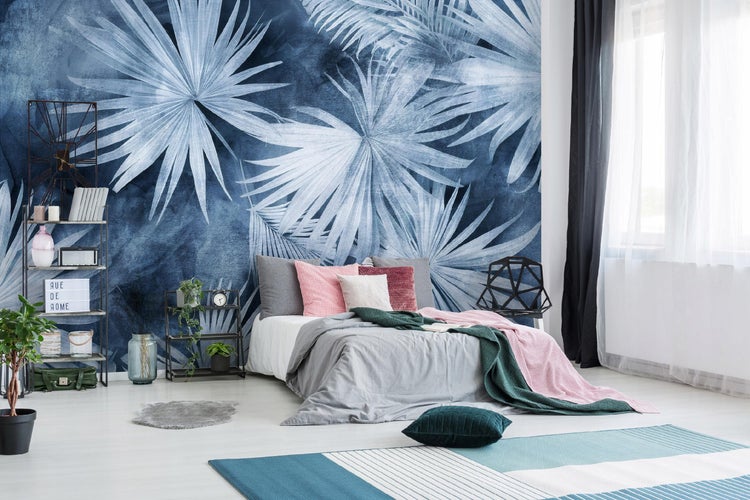 Schlafzimmer mit Bett, Regal und floraler Tapete