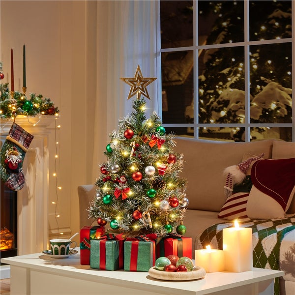 Festlich geschmückter Weihnachtsbaum mit Geschenken, Kerzen und Dekoration für eine gemütliche Weihnachtsatmosphäre