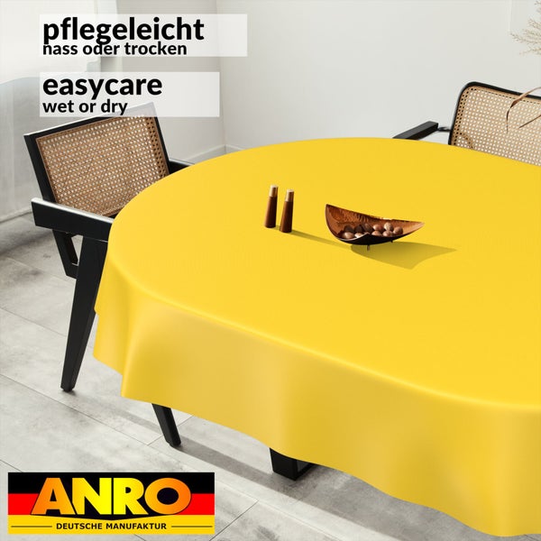 Runde, gelbe Wachstuch-Tischdecke auf einem Esstisch, pflegeleicht, nass oder trocken abwischbar. ANRO Logo.