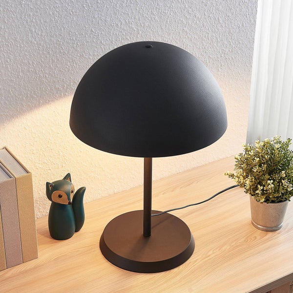 Schreibtischleuchte mit halbkugelförmigem Lampenschirm auf einem Holztisch