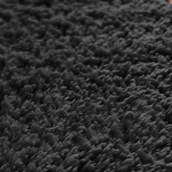 Detailansicht eines schwarzen Teppichs mit hochflorigem Flor