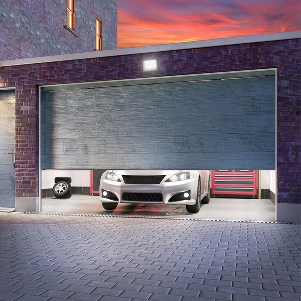 Geöffnete Garage mit Auto und Werkzeugwagen