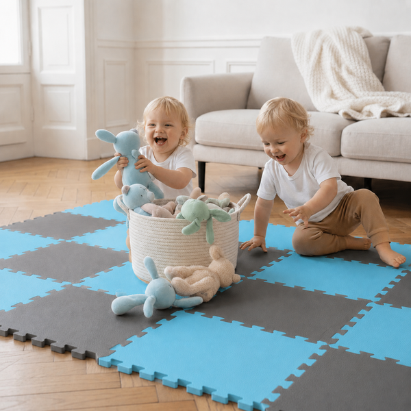 Zwei Kleinkinder spielen auf einer Puzzlematte aus Schaumstoff in einem Wohnzimmer mit Stofftieren in einem Korb.