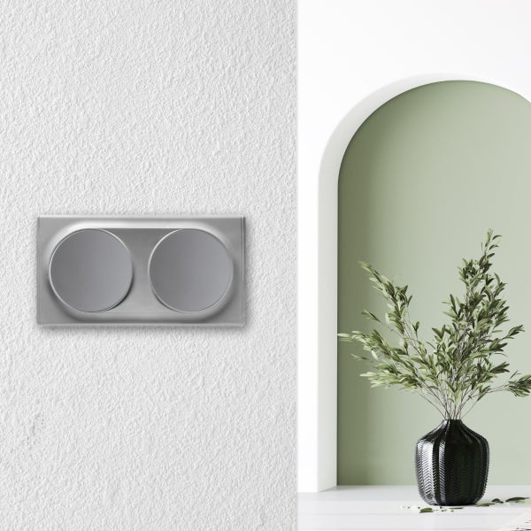 Doppelwippschalter in modernem Design an einer strukturierten Wand in einer stilvollen Wohnumgebung mit Torbogen und Dekopflanze