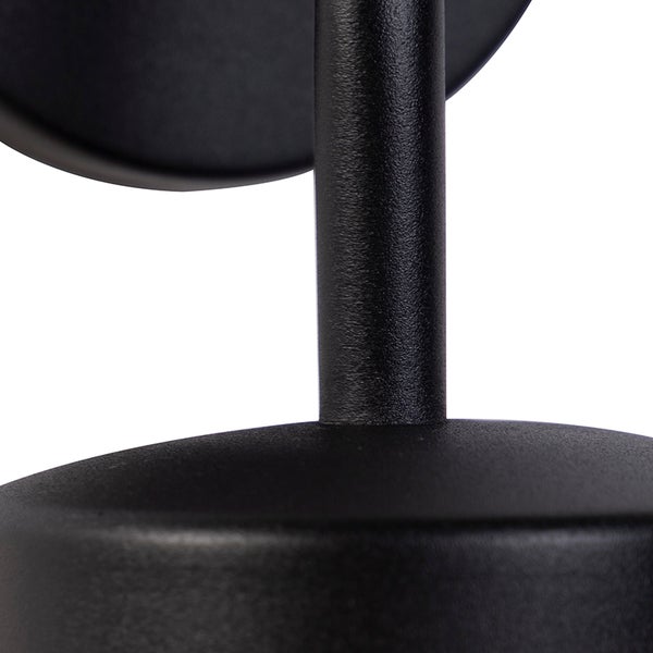 Detailaufnahme eines schwarzen, mattierten Metallgestells einer Leuchte mit strukturierter Oberfläche.