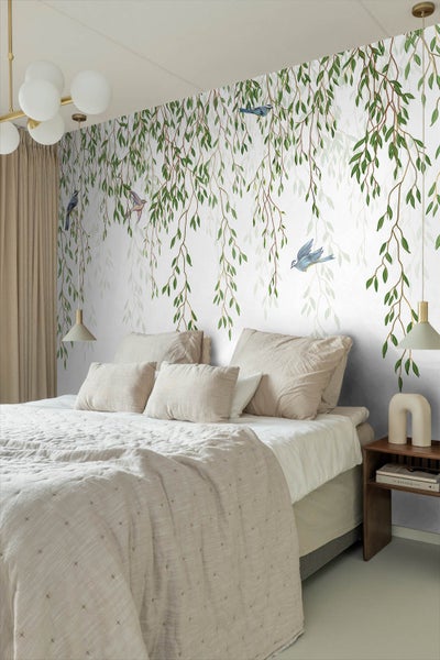 Schlafzimmer mit Bett und Wandtapete mit Blättern und Vögeln
