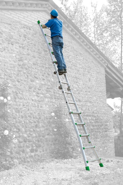 Mann auf einer Aluminiumleiter, die an einer Steinmauer lehnt