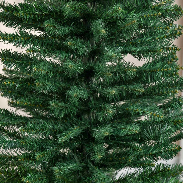 Nahaufnahme von grünen Zweigen eines künstlichen Weihnachtsbaums mit Nadeln aus Kunststoff.