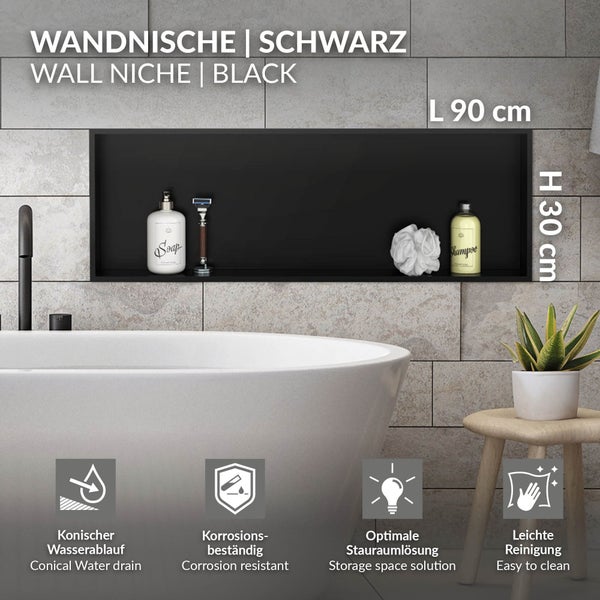 Schwarze Wandnische für das Badezimmer, 90 Zentimeter lang und 30 Zentimeter hoch, eingebaut in eine graue Fliesenwand über einer weißen Badewanne.