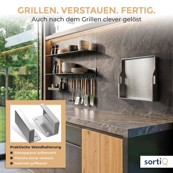 Wandhalterung aus Edelstahl zur platzsparenden Aufbewahrung einer Plancha in einer modernen Außenküche mit SortiQ Logo