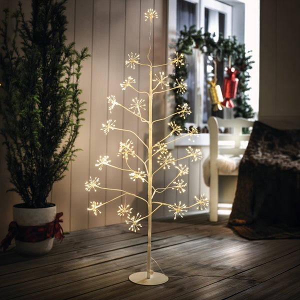 Beleuchteter Weihnachtsbaum aus Kunststoff mit LED Lichtzweigen als dekorative Zimmerbeleuchtung in weihnachtlicher Umgebung.