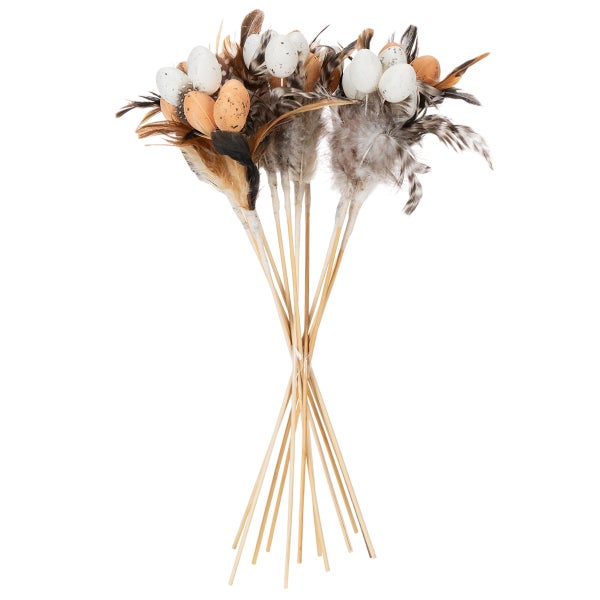 Bündel aus Ostersteckern mit dekorativen Eiern und Federn auf Holzstäben.