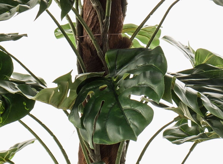 Nahaufnahme eines künstlichen Kiefernzweigs mit langen grünen Nadeln und einem braunen strukturierten Stiel.