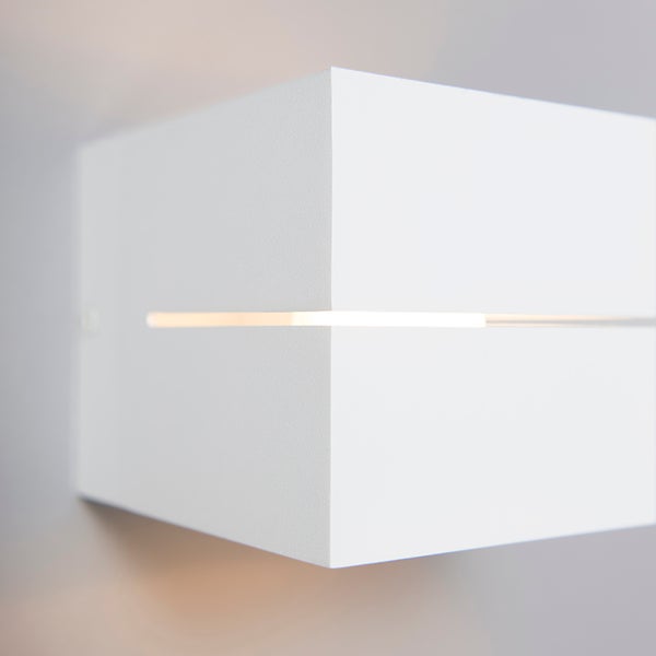 Weiße quaderförmige Wandleuchte mit Lichtschlitz