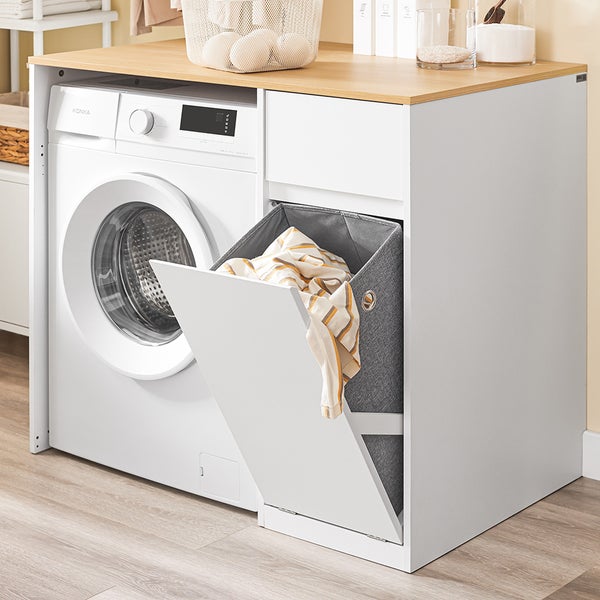 Waschmaschine mit Wäschekorb und Holzplatte in einem hellen Badezimmer