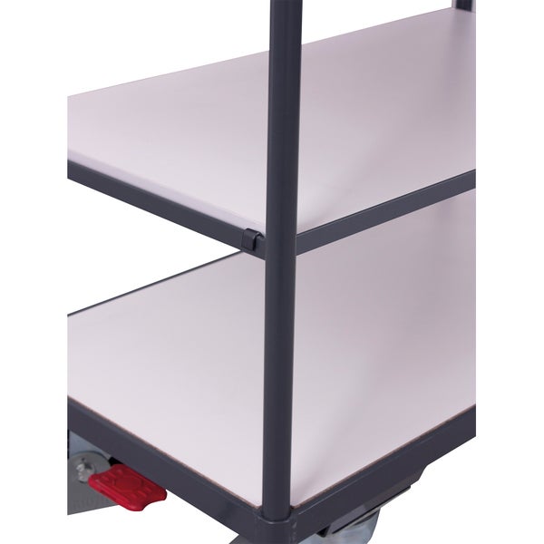 Detail eines Etagenwagens mit grauem Metallrahmen, weißen Fachböden und roter Feststellbremse.