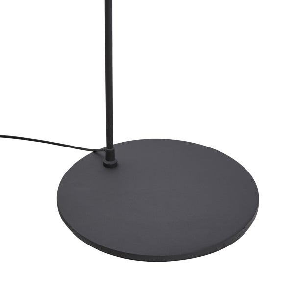 Runder Lampenfuß einer Stehlampe aus schwarzem Metall mit Stromkabel.