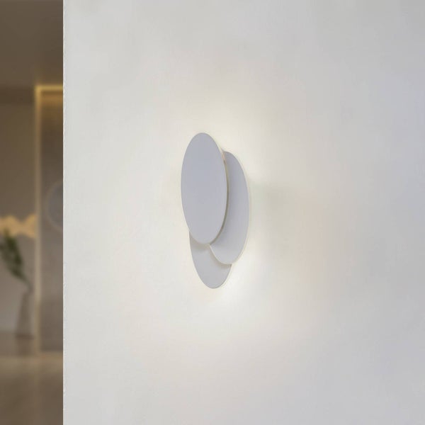 Moderne Wandleuchte mit drei überlappenden weißen runden Scheiben und indirektem Licht.