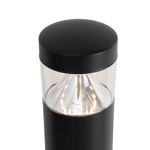 Nahaufnahme einer schwarzen zylindrischen Außenleuchte mit klarem Gehäuse und eingeschaltetem LED Leuchtmittel.