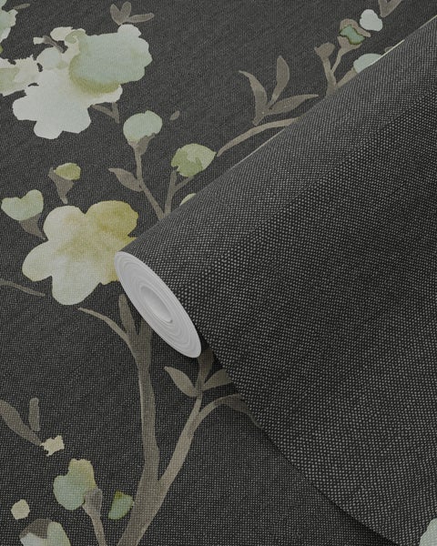 Eine Rolle Vliestapete mit Blütenmuster liegt aufgerollt da.