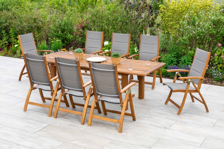 Gartenszene mit Holztisch und acht Stühlen mit Textilbespannung