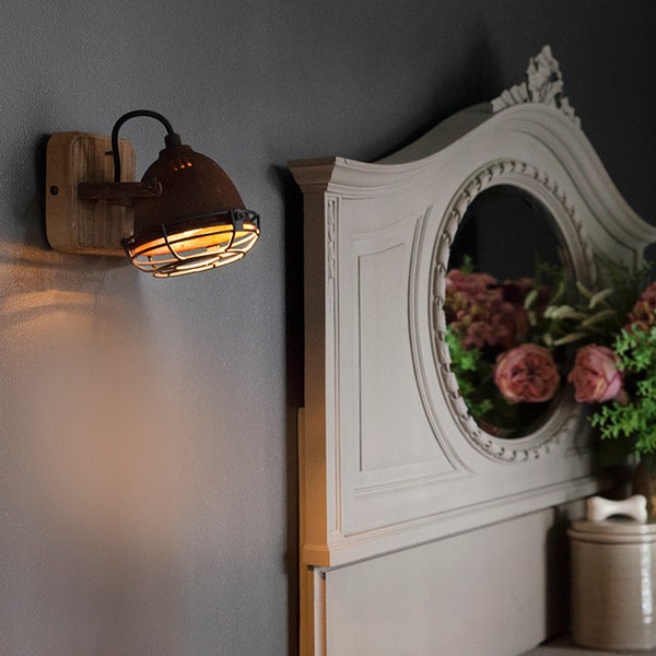 Rustikale Wandleuchte aus Holz und Metall im Interieur