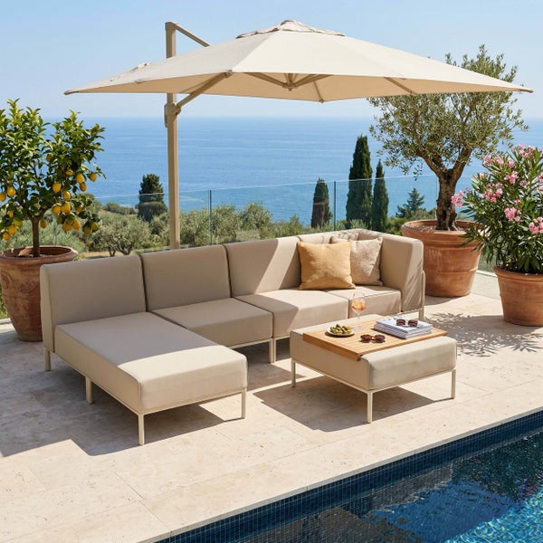 Modernes Garten-Lounge-Set aus beigen Modulen, Beistelltisch, Ampelschirm und Pflanzenkübeln auf einer sonnigen Terrasse am Pool.
