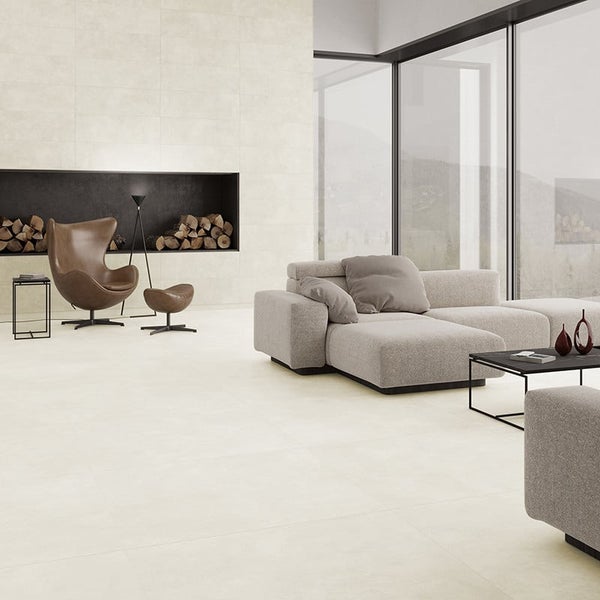 Modernes Wohnzimmer mit großformatigen Fliesen, offenem Kamin, gemütlichem Sofa, Sessel und bodentiefen Fenstern für ein helles Ambiente.