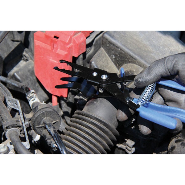 Eine Hand mit Handschuh arbeitet am Motor eines Autos