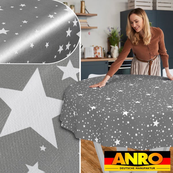 Eine Frau breitet eine runde Tischdecke mit Sternenmuster auf einem Esstisch in einer Küche aus. ANRO Logo.