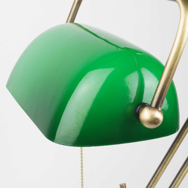 Nahaufnahme einer Schreibtischlampe mit grüner Haube und Messinggestell
