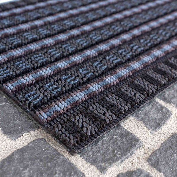 Fußmatte mit Streifenmuster auf Steinboden