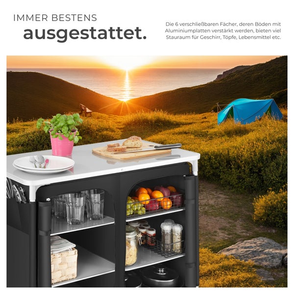 Campingküche mit Stauraum und Zubehör vor Landschaft mit Zelt
