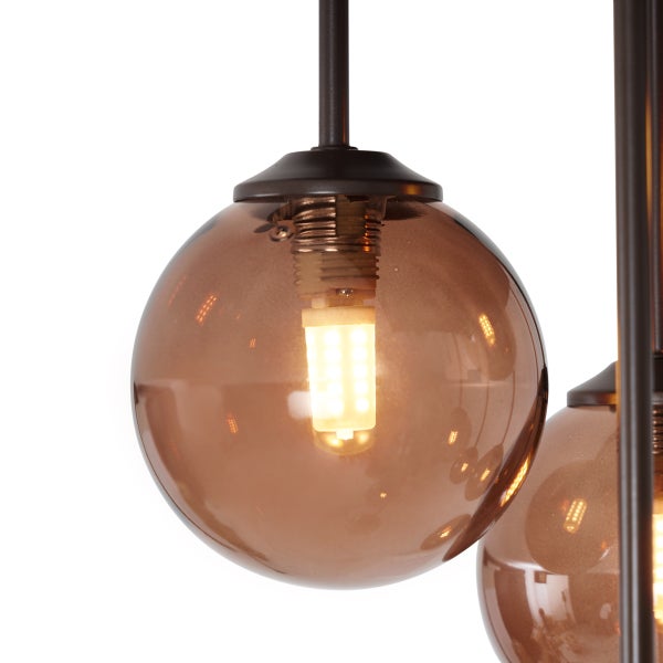 Detailaufnahme einer Pendelleuchte mit Glaskugelschirm und Leuchtmittel