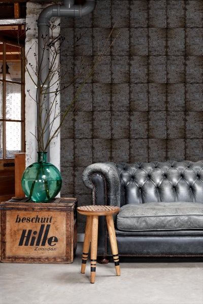 Wohnzimmer mit grauer Couch, Holzhocker und Holzkiste