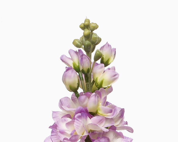 Künstliche Levkoje in Violett und Weiß mit grünen Blättern.
