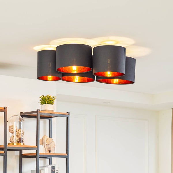 Deckenleuchte mit fünf schwarzen Stoffschirmen und kupferfarbener Innenseite, montiert in einem hellen, modern eingerichteten Raum.