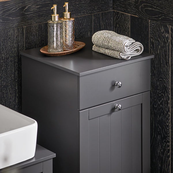 Grauer Badezimmerschrank mit Schublade, Tür, Handtüchern und Seifenspendern