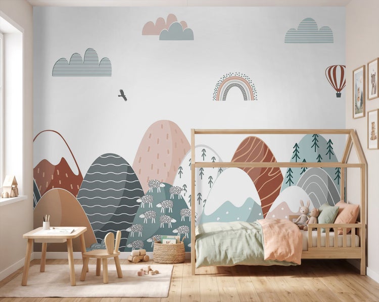 Kinderzimmer mit Fototapete Berglandschaft, einem Hausbett aus Holz und einem kleinen Schreibtisch mit Hasenohren-Stuhl.