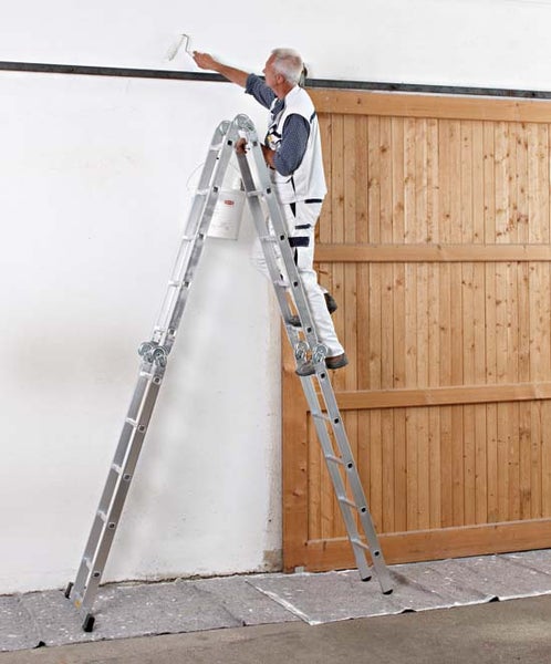 Mann auf Mehrzweckleiter streicht Wand mit Farbroller