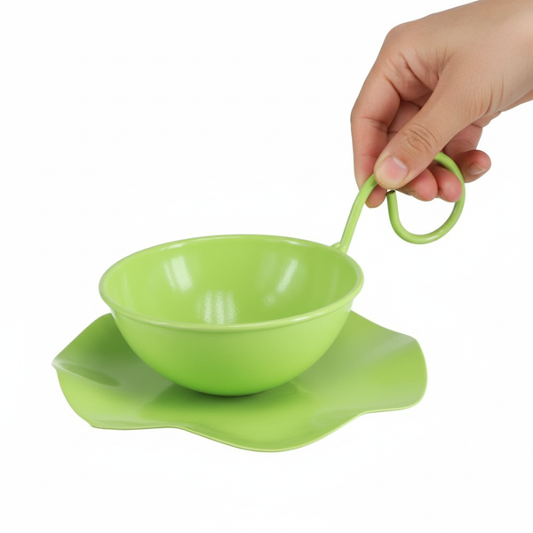 Dekorative grüne Tasse aus Metall mit Untertasse und Griff, gehalten von einer Hand.