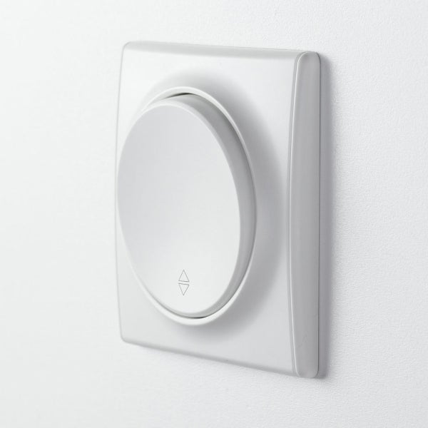 Rollladenschalter mit quadratischem Rahmen und rundem Bedienelement zur Steuerung von Jalousien und Rollläden an einer Wand