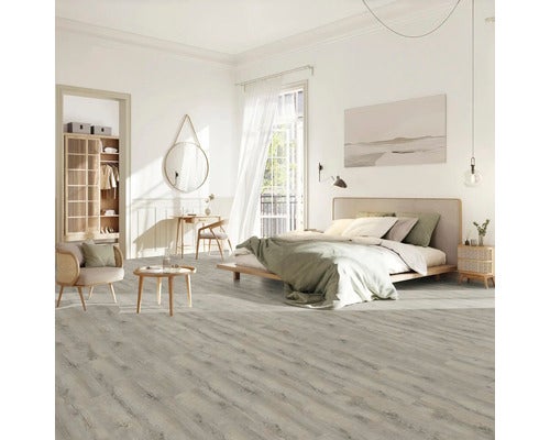 Heller Schlafzimmerraum mit Laminatboden, Bett, Sitzgelegenheit und Arbeitsplatz.