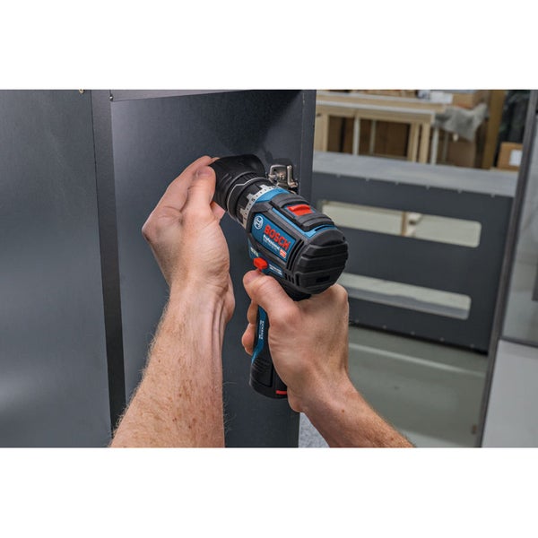 Handwerker verwendet einen Bosch Professional Akku Bohrschrauber mit Winkelaufsatz zur Montage eines Scharniers an einem Möbelstück.