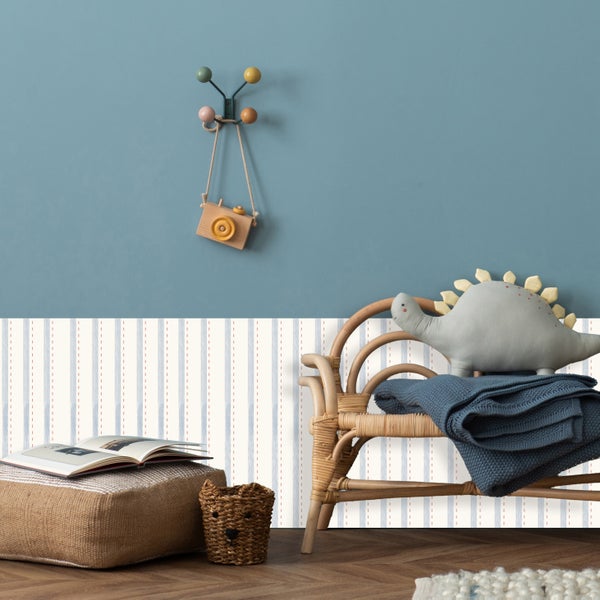 Gemütliches Kinderzimmer mit Rattan-Stuhl, Kissen, Decke und dekorativen Accessoires