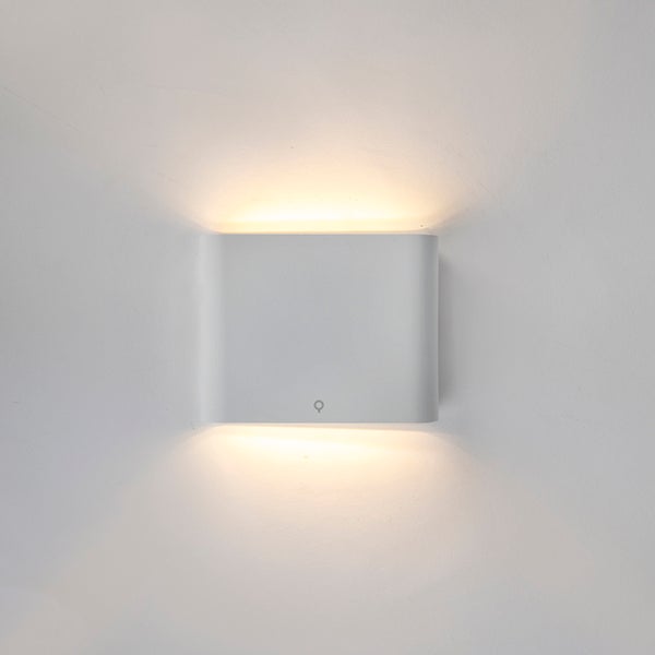 Weiße, rechteckige Wandleuchte mit abgerundeten Kanten und Lichtaustritt nach oben und unten.