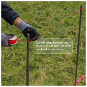 Person mit Arbeitshandschuhen spannt eine Markierschnur zwischen Pflöcken auf einer Rasenfläche zur Abgrenzung.