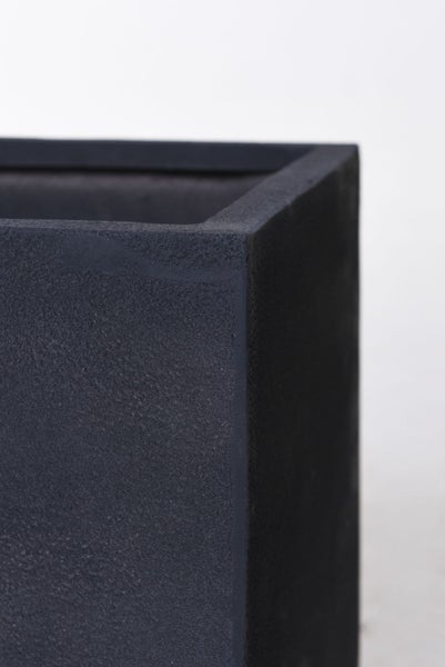 Detailaufnahme der Ecke eines Pflanzgefäßes mit rauer, strukturierter Oberfläche in Steinoptik.